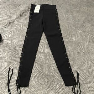Black knit skinny pants with gold grommets and braided side size small.